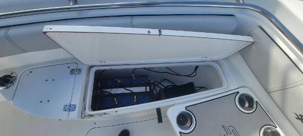 Slide: The Image of Open storage compartment on a 2020 Sea Pro 239CC boat showing wiring and battery setup. - 14