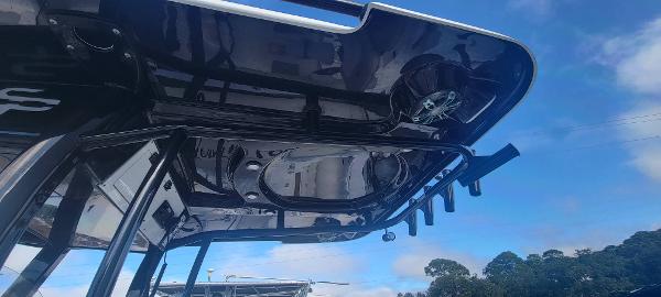 Slide: The Image of 2020 Sea Pro 239CC boat T-top with rod holders against blue sky. - 24