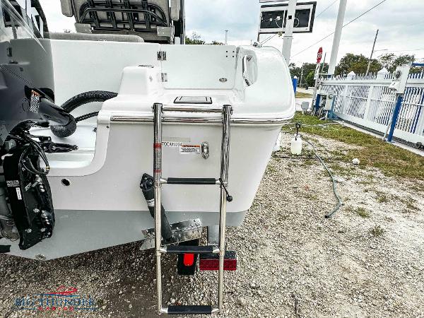 Slide: The Image of 2023 Sea Pro 239 DLX boat with rear ladder and outboard motor. - 10