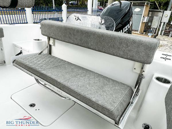 Slide: The Image of 2023 Sea Pro 239 DLX boat with cushioned seating and Suzuki outboard motor. - 14