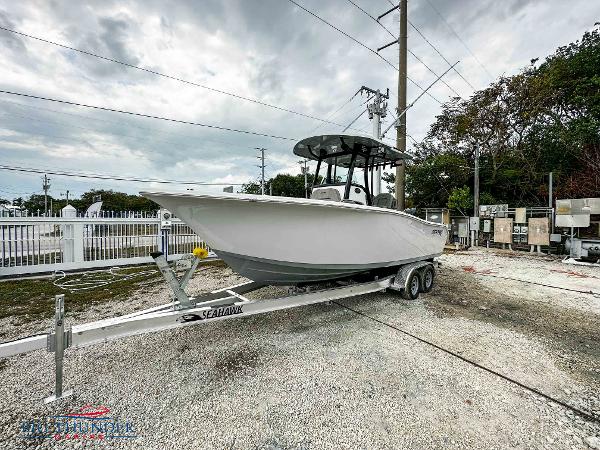 Slide: The Image of 2023 Sea Pro 239 DLX boat on a trailer in a marina. - 2