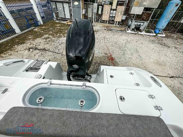 Slide: The Image of 2023 Sea Pro 239 DLX boat with outboard motor and livewell, viewed from the stern. - 21