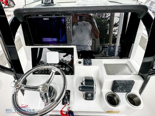 Slide: The Image of 2023 Sea Pro 239 DLX boat dashboard with steering wheel, controls, and electronics. - 27