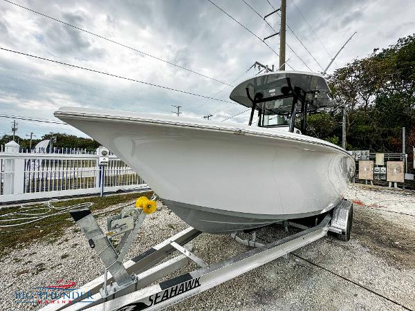 Slide: The Image of 2023 Sea Pro 239 DLX boat on a Seahawk trailer, parked outdoors. - 3