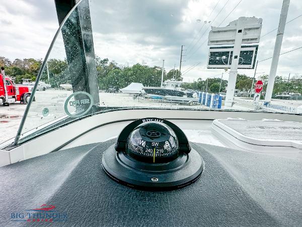 Slide: The Image of 2023 Sea Pro 239 DLX boat dashboard with compass and windshield view. - 35