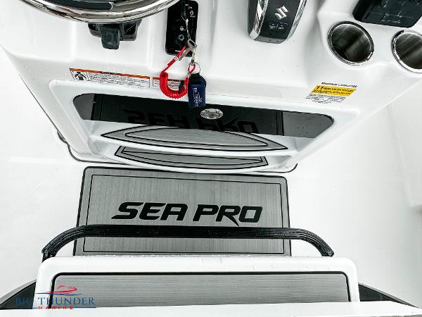 Slide: The Image of 2023 Sea Pro 239 DLX boat console with steering wheel and cup holders. - 39