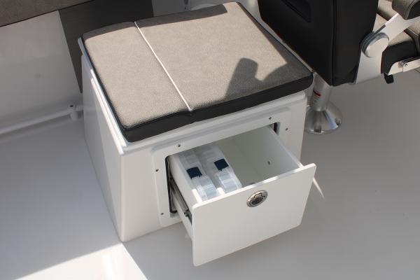 Slide: The Image of Sea Pro 240 2024 boat storage compartment with cushioned seat and open drawer. - 25