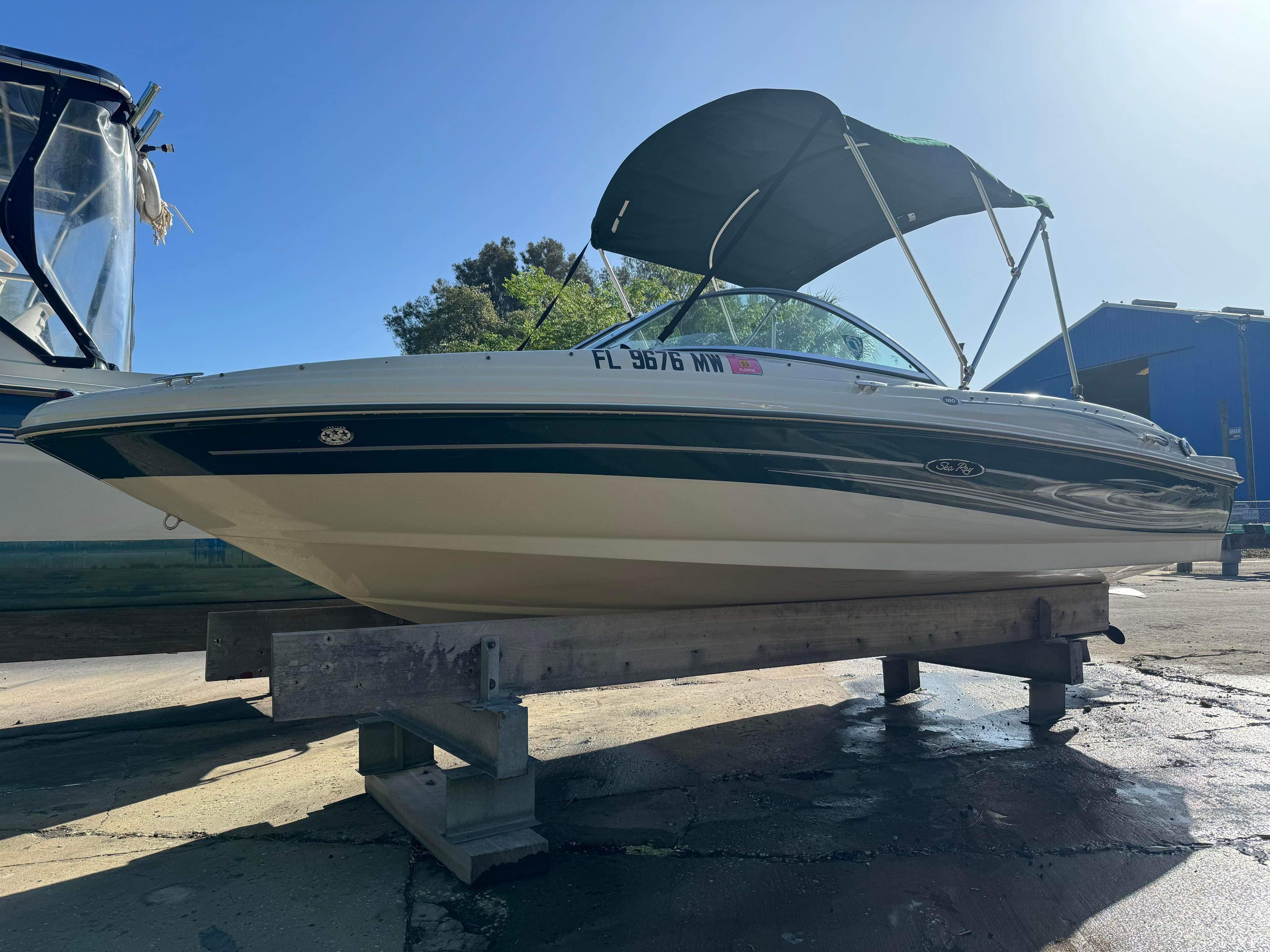 Slide: The Image of 2005 Sea Ray 180 Sport boat on a stand, side view with blue sky background. - 0