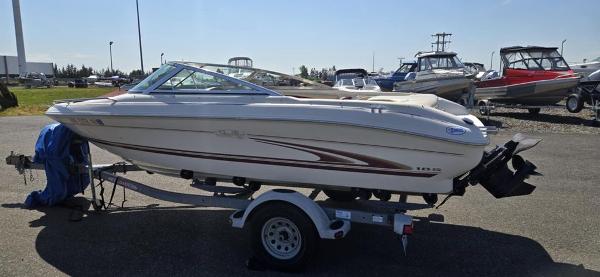 Slide: The Image of 1999 Sea Ray 185 Bow Rider boat on trailer in outdoor lot. - 2