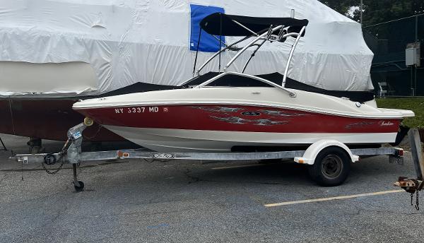 Slide: The Image of 2007 Sea Ray 185 Sport boat on trailer, red and white design, parked outdoors. - 0