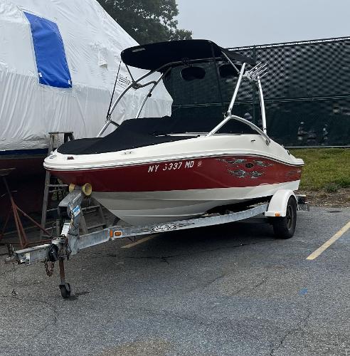 Slide: The Image of 2007 Sea Ray 185 Sport boat on trailer, red and white, parked outdoors. - 2