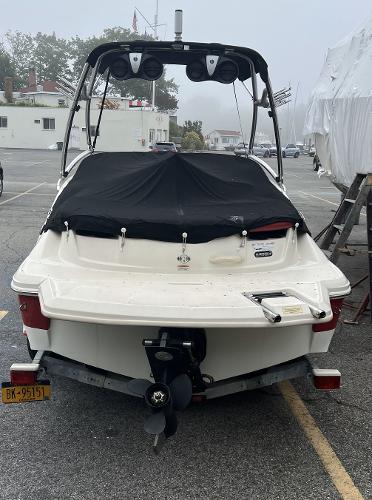 Slide: The Image of 2007 Sea Ray 185 Sport boat with covered seating, parked in a marina. - 3