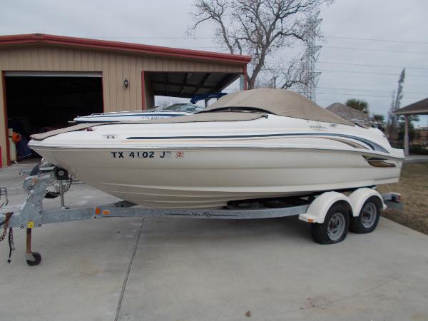 Slide: The Image of 2001 Sea Ray 190 Sundeck boat on a trailer in front of a garage. - 1