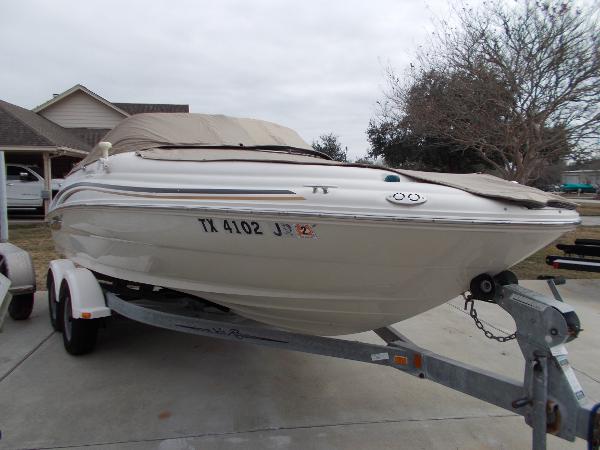 Slide: The Image of 2001 Sea Ray 190 Sundeck boat on trailer, covered and parked in driveway. - 2