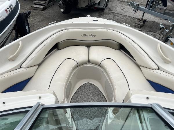 Slide: The Image of 2004 Sea Ray 200 Select boat interior with white cushioned seating and sleek design. - 2