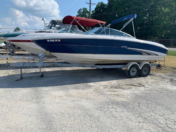 Slide: The Image of 2000 Sea Ray 210 Bow Rider on a trailer in a boatyard. - 0