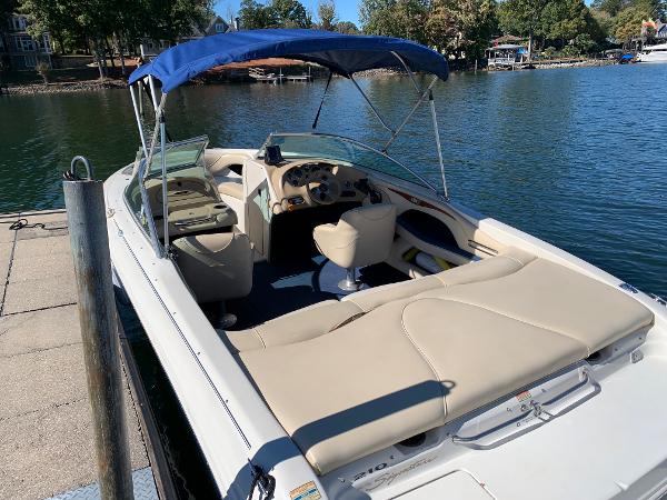 Slide: The Image of 2000 Sea Ray 210 Bow Rider boat docked by a lake with blue canopy. - 6