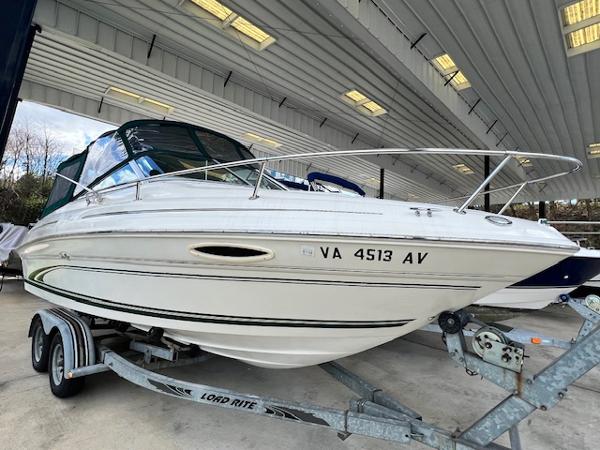 Slide: The Image of 1999 Sea Ray 215 Express Cruiser on a trailer in a covered storage area. - 0
