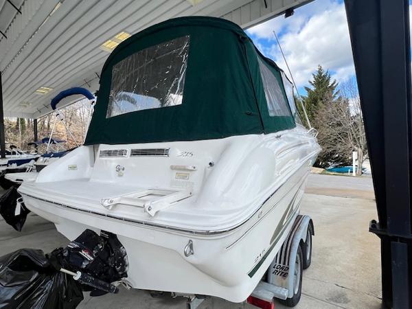 Slide: The Image of 1999 Sea Ray 215 Express Cruiser on trailer under a covered dock. - 1