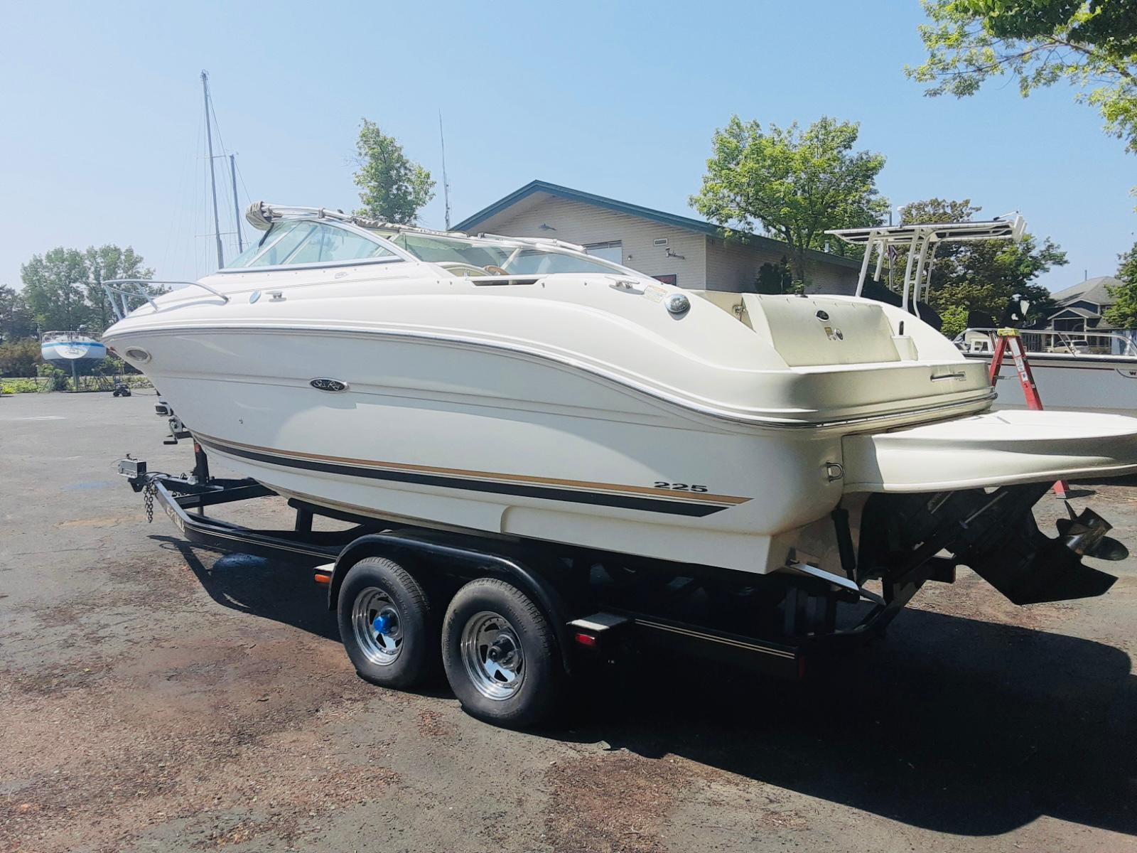 Slide: The Image of 2001 Sea Ray 225 Weekender boat on trailer, parked outdoors. - 0