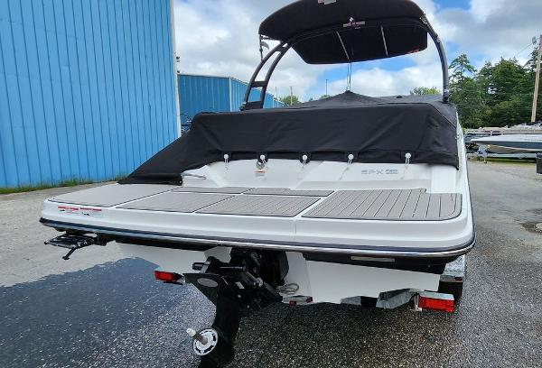 Slide: The Image of 2024 Sea Ray 230 SPX boat rear view with black canopy and swim platform. - 3