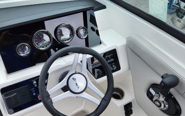 Slide: The Image of 2024 Sea Ray 230 SPX boat dashboard with steering wheel and control panel. - 6