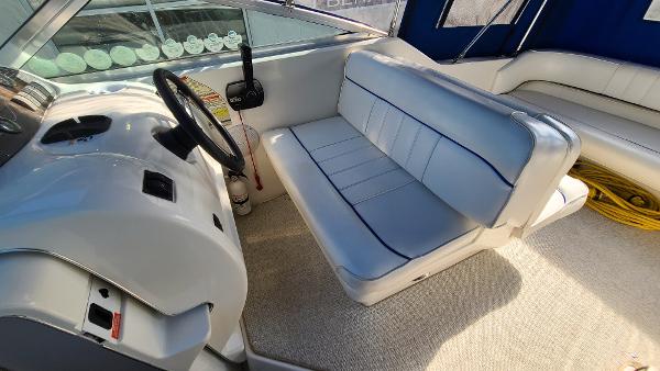 Slide: The Image of 1996 Sea Ray 240 Sundancer boat interior with steering wheel and seating area. - 10
