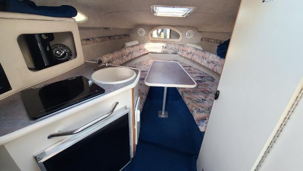 Slide: The Image of 1996 Sea Ray 240 Sundancer cabin interior with kitchenette and seating area. - 14