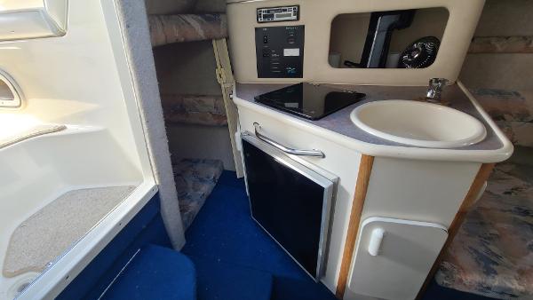 Slide: The Image of 1996 Sea Ray 240 Sundancer cabin interior with kitchenette and seating area. - 15