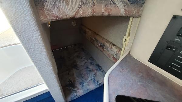 Slide: The Image of 1996 Sea Ray 240 Sundancer cabin interior with patterned upholstery and control panel. - 17