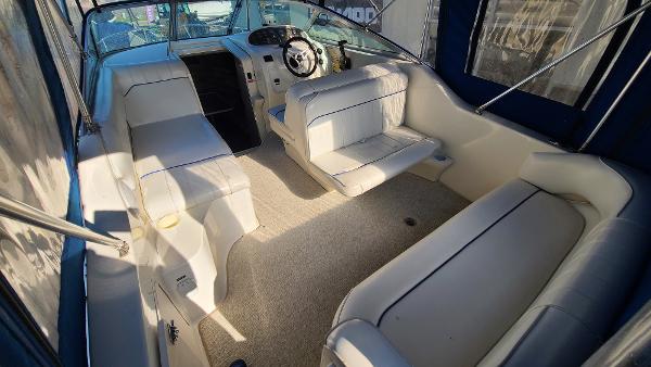Slide: The Image of 1996 Sea Ray 240 Sundancer boat interior with white seating and steering console. - 6