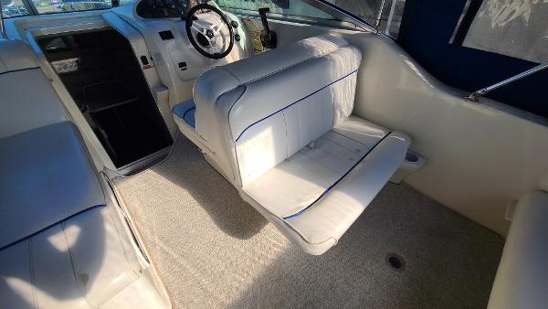 Slide: The Image of Interior of a 1996 Sea Ray 240 Sundancer boat with white seating and steering wheel. - 9