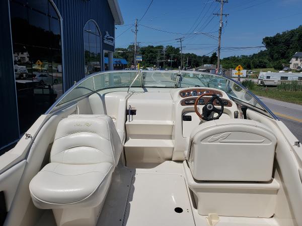 Slide: The Image of 2001 Sea Ray 245 Weekender boat interior with white seating and steering wheel. - 1