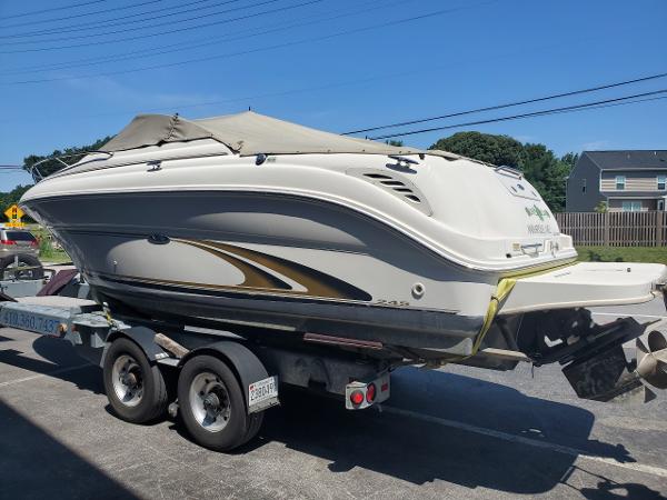Slide: The Image of 2001 Sea Ray 245 Weekender boat on trailer, parked outdoors under clear sky. - 4