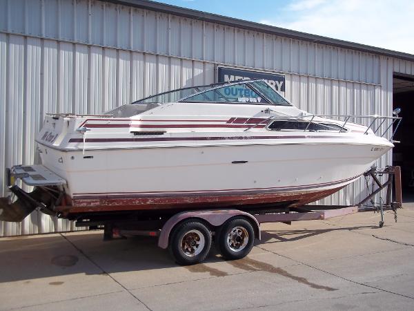 Slide: The Image of 1984 Sea Ray SRV 260 Sundancer on trailer outside metal building. - 0