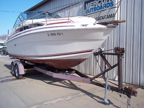 Slide: The Image of 1984 Sea Ray SRV 260 Sundancer on trailer outside marine shop. - 1
