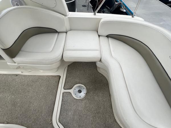 Slide: The Image of 2005 Sea Ray 260 Sundancer boat interior seating area with gray carpet. - 10