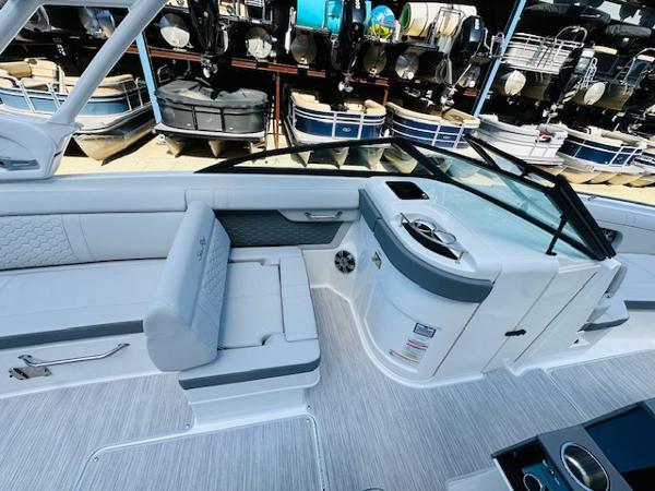Slide: The Image of 2025 Sea Ray 270 SDX boat interior with seating and storage, docked near other boats. - 17