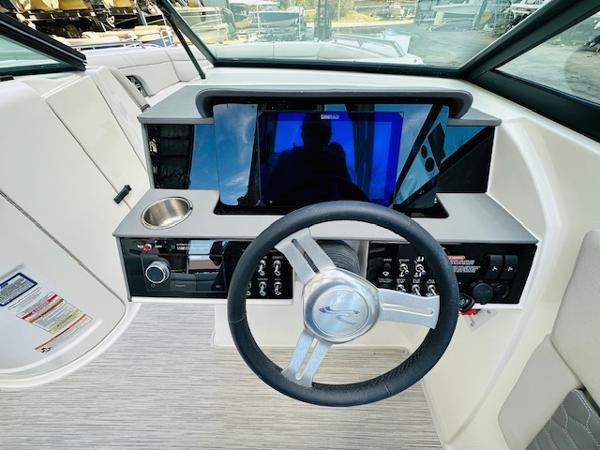 Slide: The Image of 2025 Sea Ray 270 SDX boat dashboard with steering wheel and modern controls. - 20