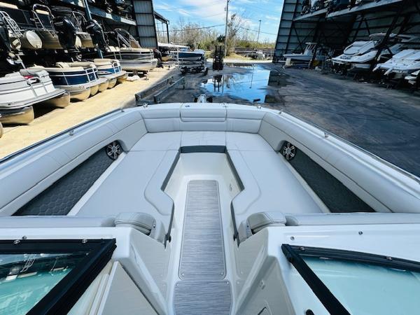 Slide: The Image of 2025 Sea Ray 270 SDX boat interior with spacious seating in a marina setting. - 23