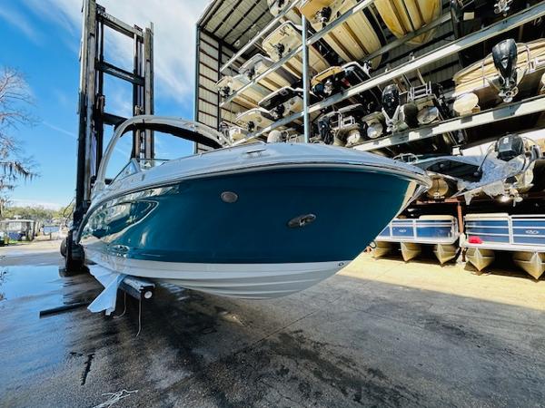 Slide: The Image of 2025 Sea Ray 270 SDX boat in storage, blue hull, outdoor marina setting. - 4