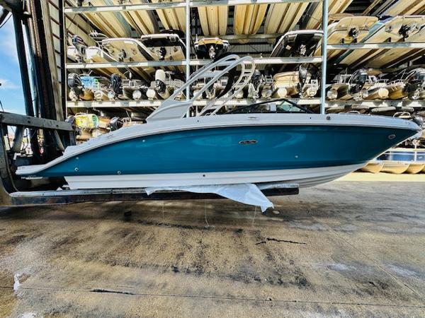 Slide: The Image of 2025 Sea Ray 270 SDX boat in storage, side view, blue and white hull. - 5
