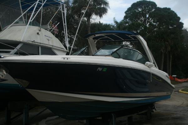 Slide: The Image of 2014 Sea Ray 270 SLX boat docked on land with trees in the background. - 0
