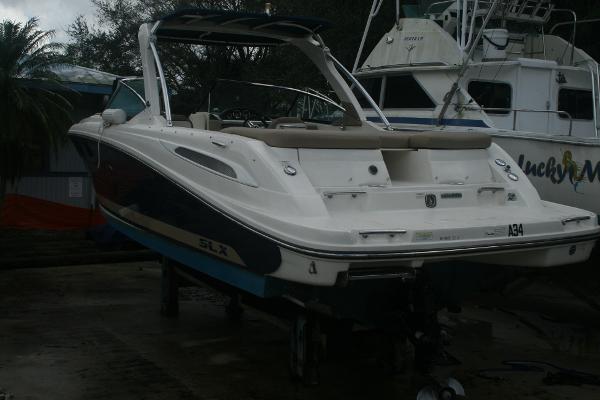 Slide: The Image of 2014 Sea Ray 270 SLX boat on a trailer, docked near other boats. - 1