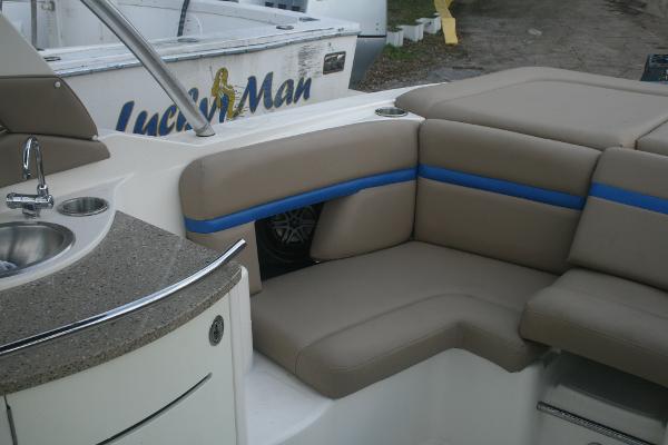 Slide: The Image of 2014 Sea Ray 270 SLX boat interior with beige seating and kitchenette. - 13