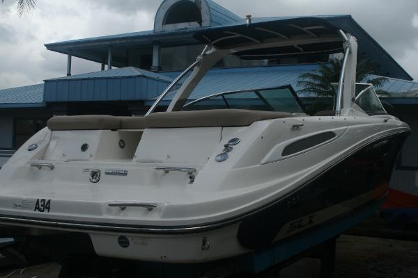 Slide: The Image of 2014 Sea Ray 270 SLX boat docked near a blue building. - 3