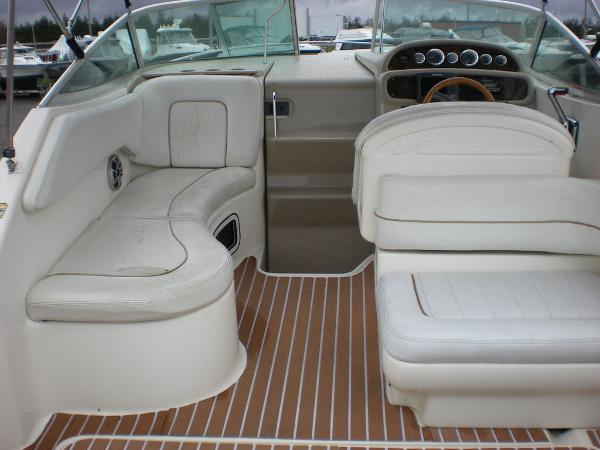 Slide: The Image of 1998 Sea Ray Sundancer 270 boat interior with white seating and wooden flooring. - 1