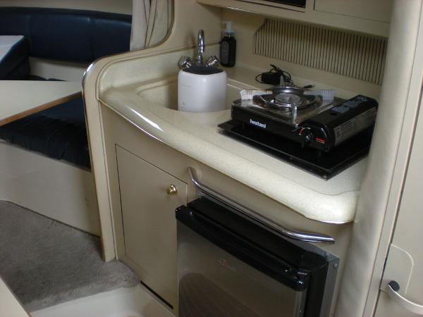 Slide: The Image of Compact kitchen area in a 1998 Sea Ray Sundancer 270 boat with stove and mini-fridge. - 11