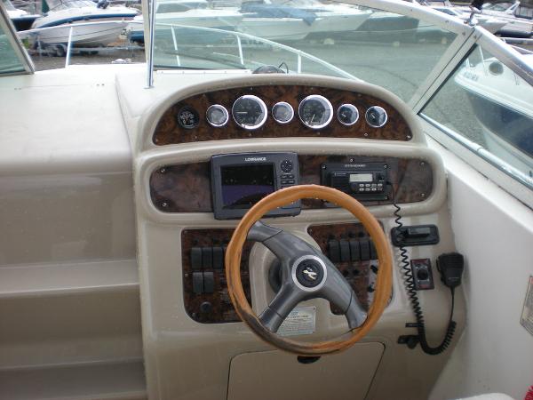 Slide: The Image of 1998 Sea Ray Sundancer 270 helm with steering wheel, gauges, and navigation equipment. - 3