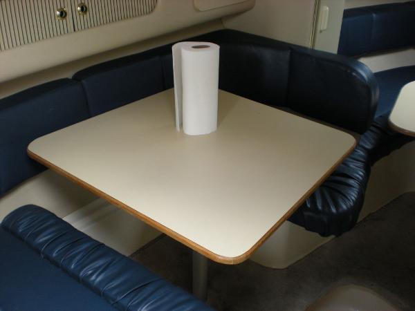 Slide: The Image of 1998 Sea Ray Sundancer 270 cabin dining area with table and blue seating. - 8